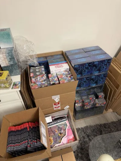 Pokémon boxes and packs stacked in open shipping cartons