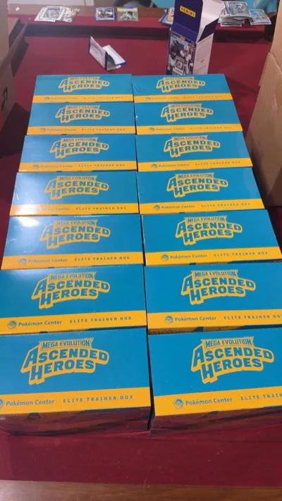 Blue-and-yellow Ascended Heroes Elite Trainer Boxes arranged on a table