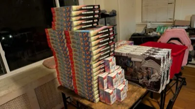 Pokémon collection boxes piled across a table by a window