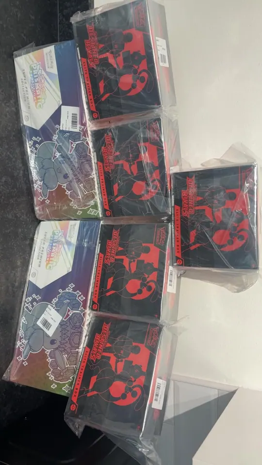 Red-and-black Pokémon boxes stacked beside reflective collection boxes