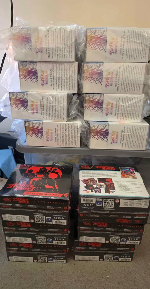 Tall stacks of pale Pokémon product boxes above rows of dark collection boxes