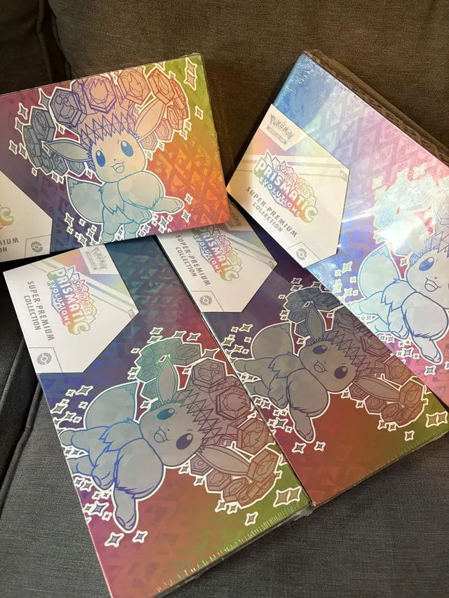Prismatic Evolutions boxes spread across a dark tabletop.