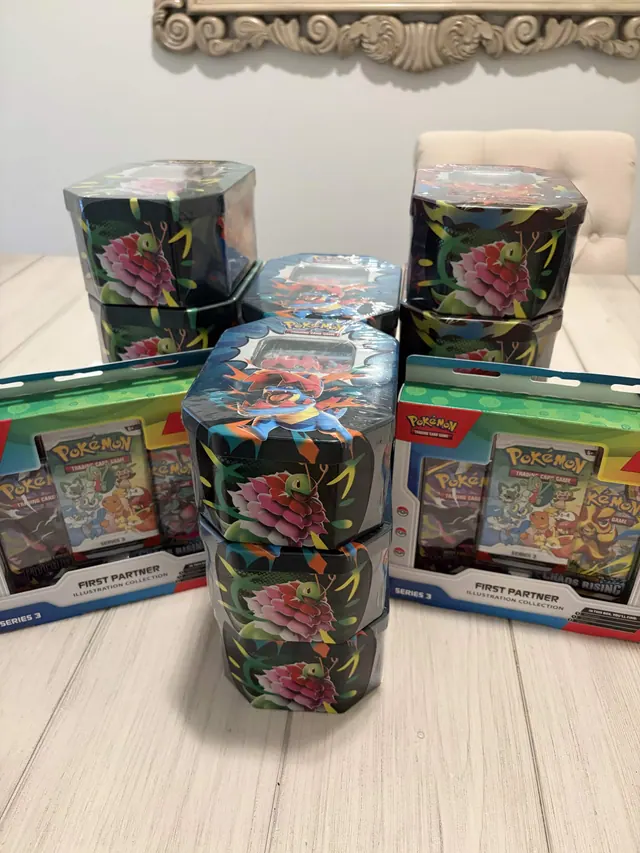 Pokémon tins and boxed trading-card collections arranged on a table.
