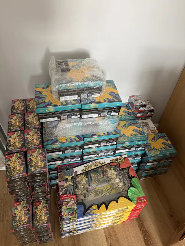 Large stacks of Pokémon collection boxes arranged in a room corner.