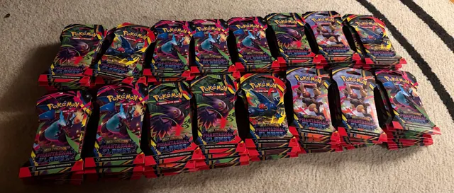 Rows of Charizard-themed Pokémon tins laid out on a rug.