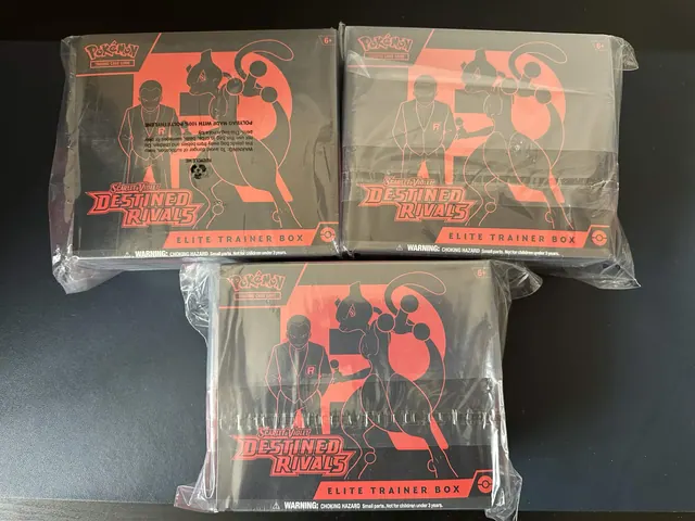 Three wrapped Destined Rivals Elite Trainer Boxes on a dark surface.