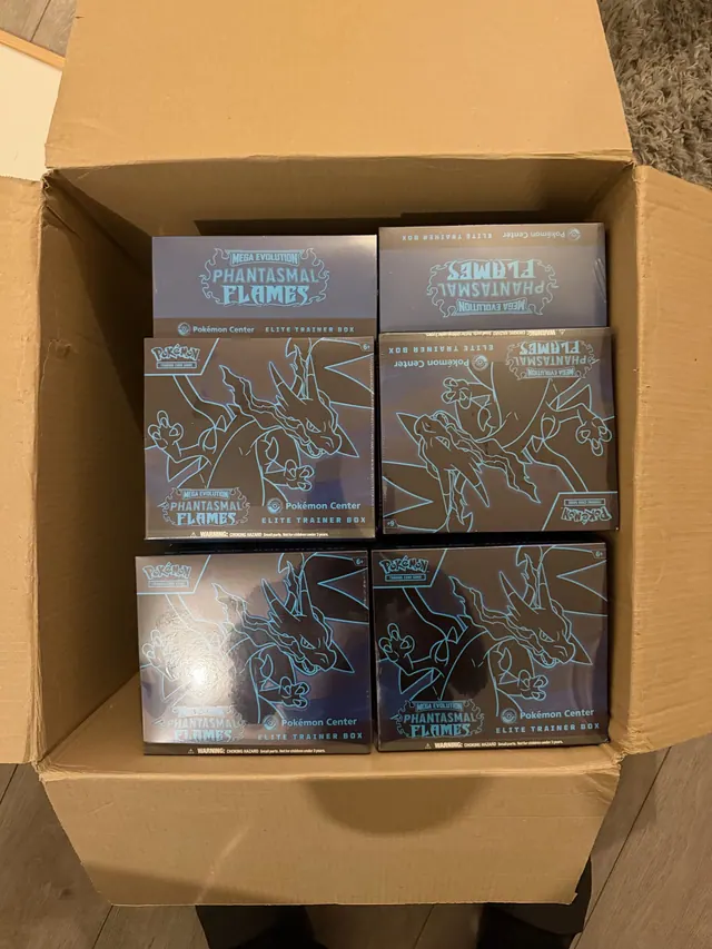 Phantasmal Flames Pokémon Center Elite Trainer Boxes inside an open carton.