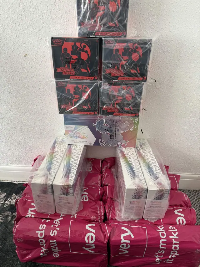Destined Rivals boxes stacked over wrapped Pokémon products and shopping bags.