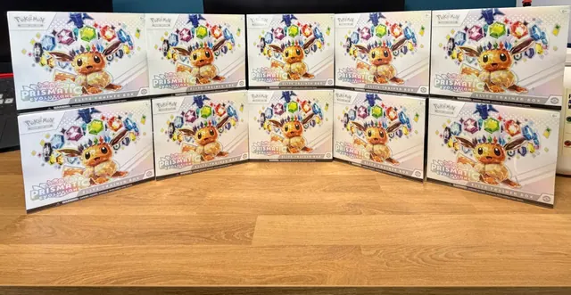 Two rows of Eevee-themed Prismatic Evolutions Elite Trainer Boxes on a table