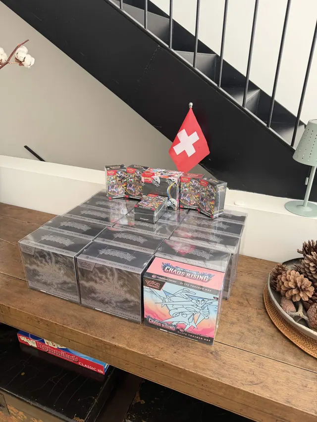Sealed Pokémon card boxes arranged across a wooden table.