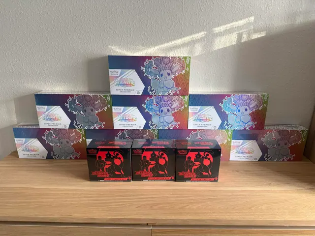 Prismatic Evolutions and Destined Rivals boxes arranged on a wooden tabletop.