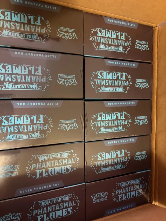 Phantasmal Flames Elite Trainer Boxes stacked inside a wooden cabinet.